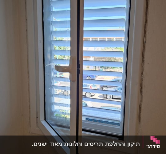 חלון אלומיניום לבן שנפתח על ציר עם תריס שלבים